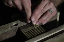 Brian Timmons colocando detalhes finais em um pente de barba de madeira